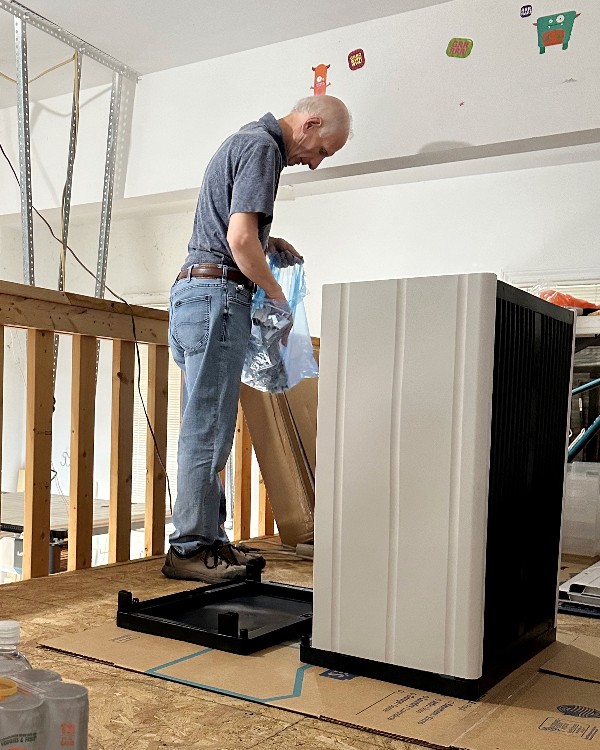 Man assembling plastic cupboards in garage for Nolensville Home Organizing