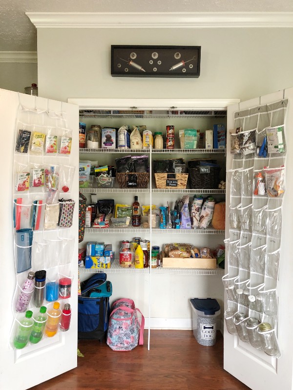 Wide closet pantry with wire shelving and clear over the door shoe organizers holding water bottles Organized by Nolensville Home Organizing