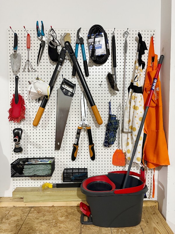 Garage pegboard wall with gardening tools organized by Nolensville Home Organizing