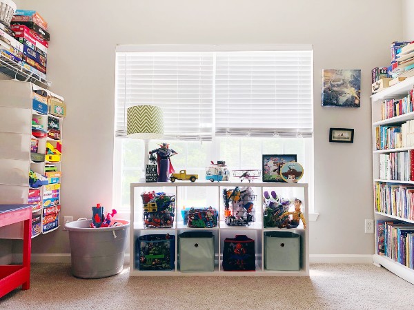 Playroom with hanging organizers for board games and a cubby and cube bins for toys organized by Nolensville Home Organizing